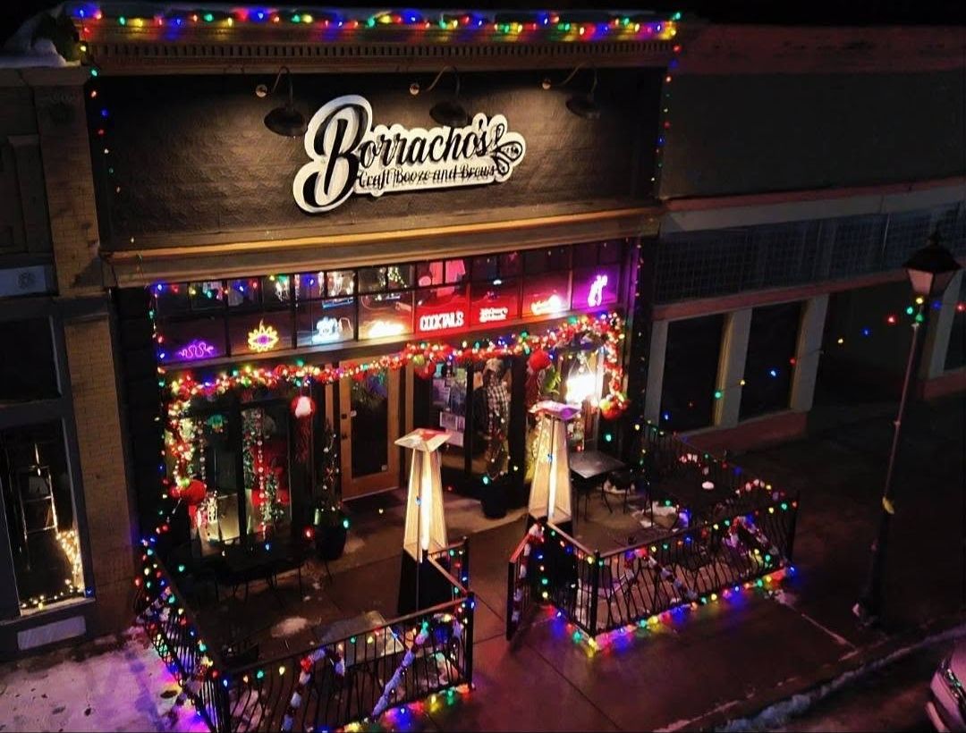 Borracho's storefront on Bridge St lit up with holiday lights at night